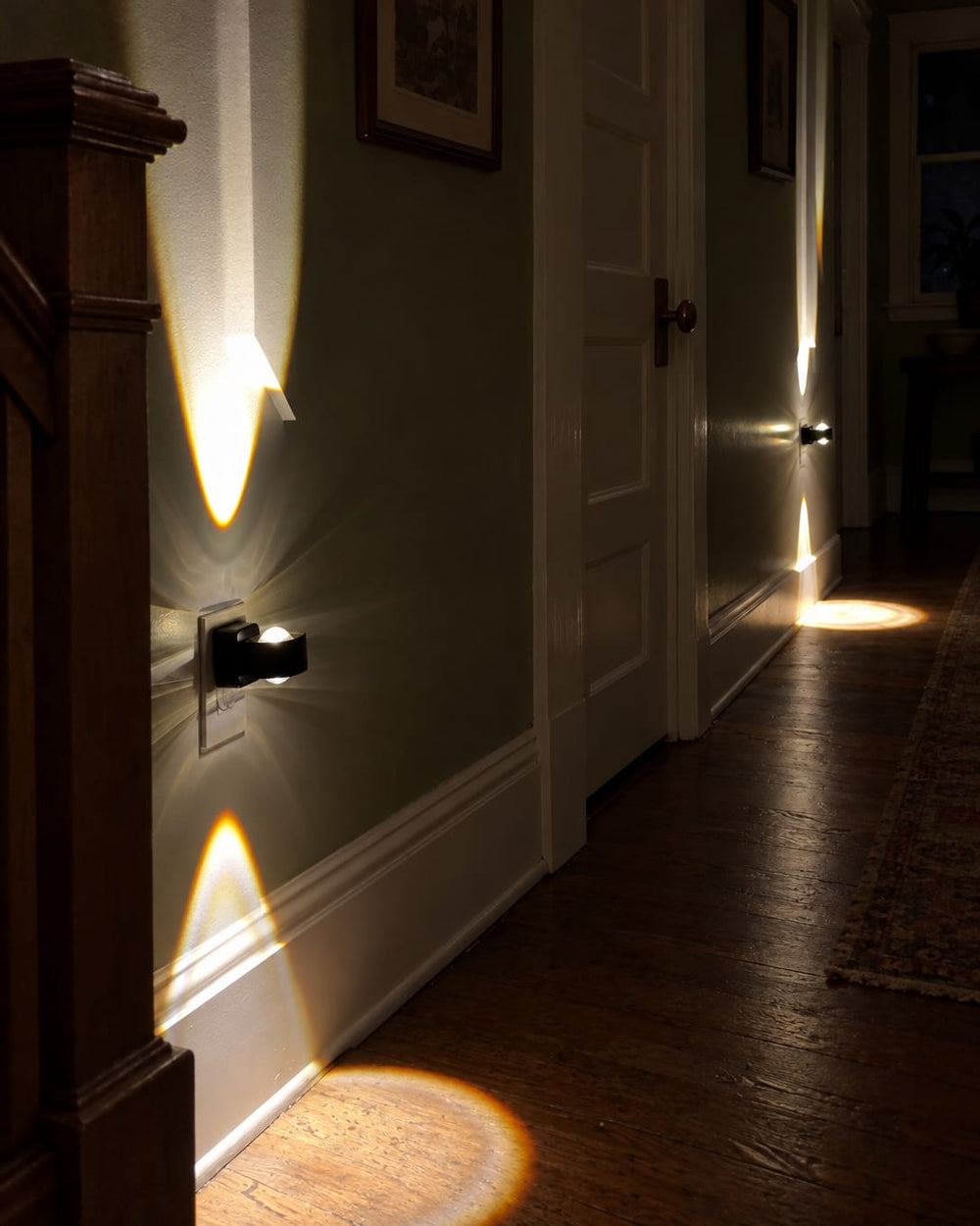 Aoraglow glowing warm up and down the wall of a craftsman hallway at night, the hall dark around it, cut to 4:5